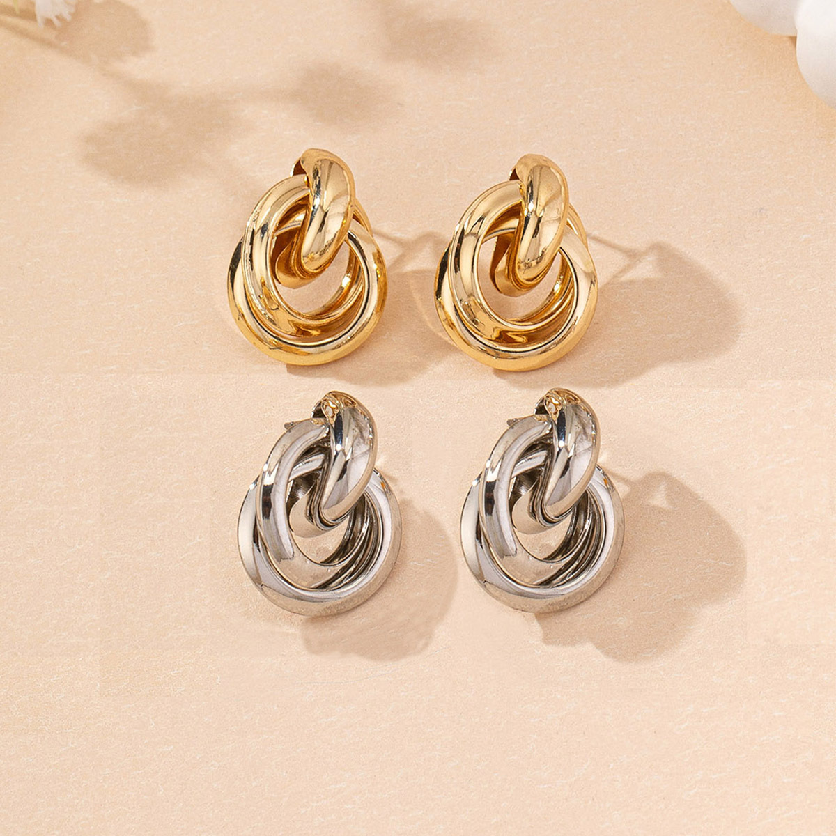 Two sets of gold and silver round earrings