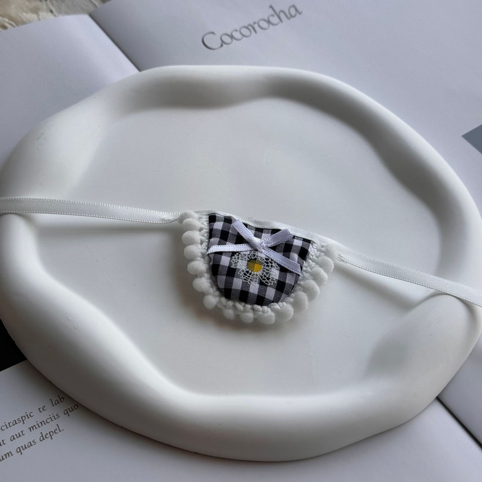 Black fur ball-edged bow bib