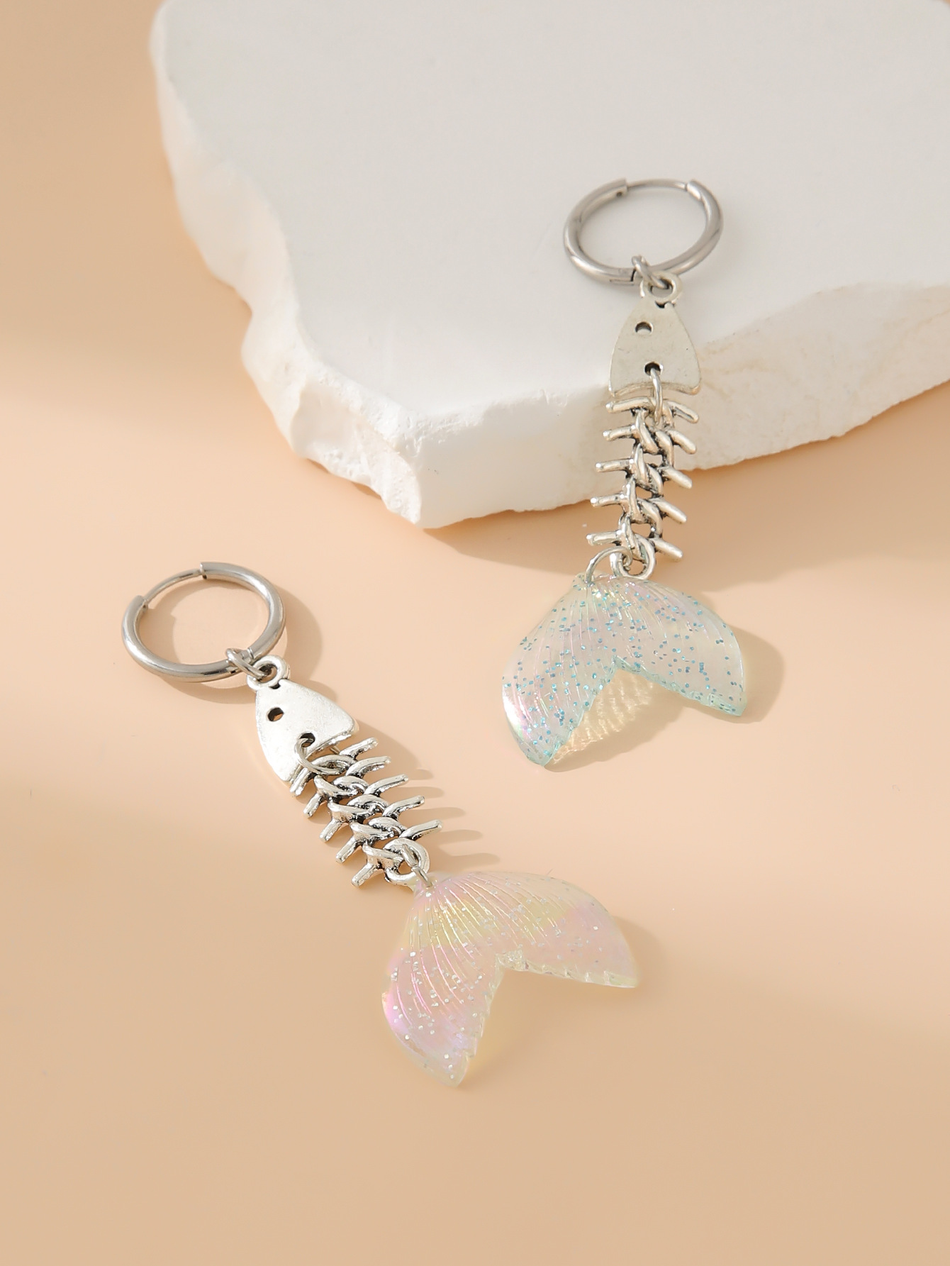 A pair of fishbone earrings light pink